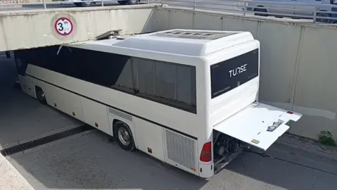 Manavgat’ta 3 metreyi aşan tur otobüsü alt geçide sıkıştı